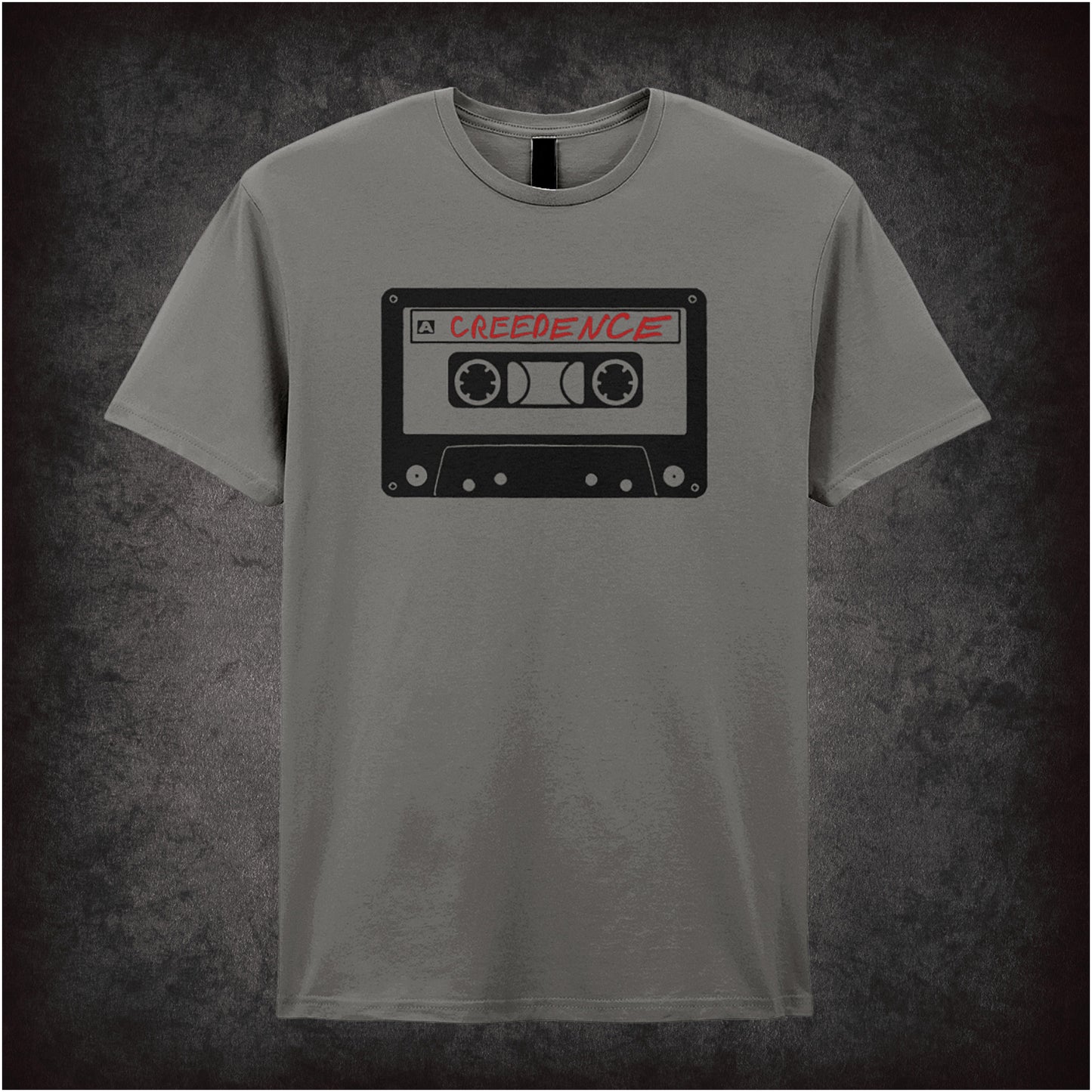 Creedence Tape – The Big Lebowski-inspired design featuring a vintage cassette tape labelled “Creedence” printed on a charcoal unisex t-shirt.