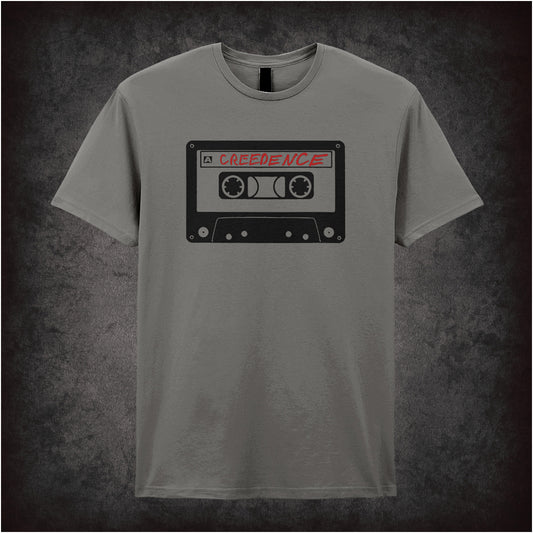 Creedence Tape – The Big Lebowski-inspired design featuring a vintage cassette tape labelled “Creedence” printed on a charcoal unisex t-shirt.