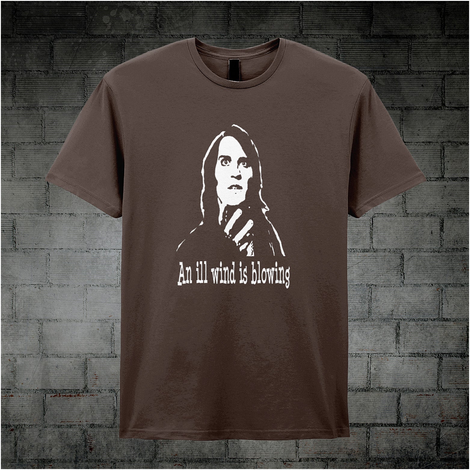 chocolate unisex T-shirt featuring the phrase “An Ill Wind Is Blowing” inspired by The IT Crowd, displayed in bold white text with a dramatic, minimalist design.