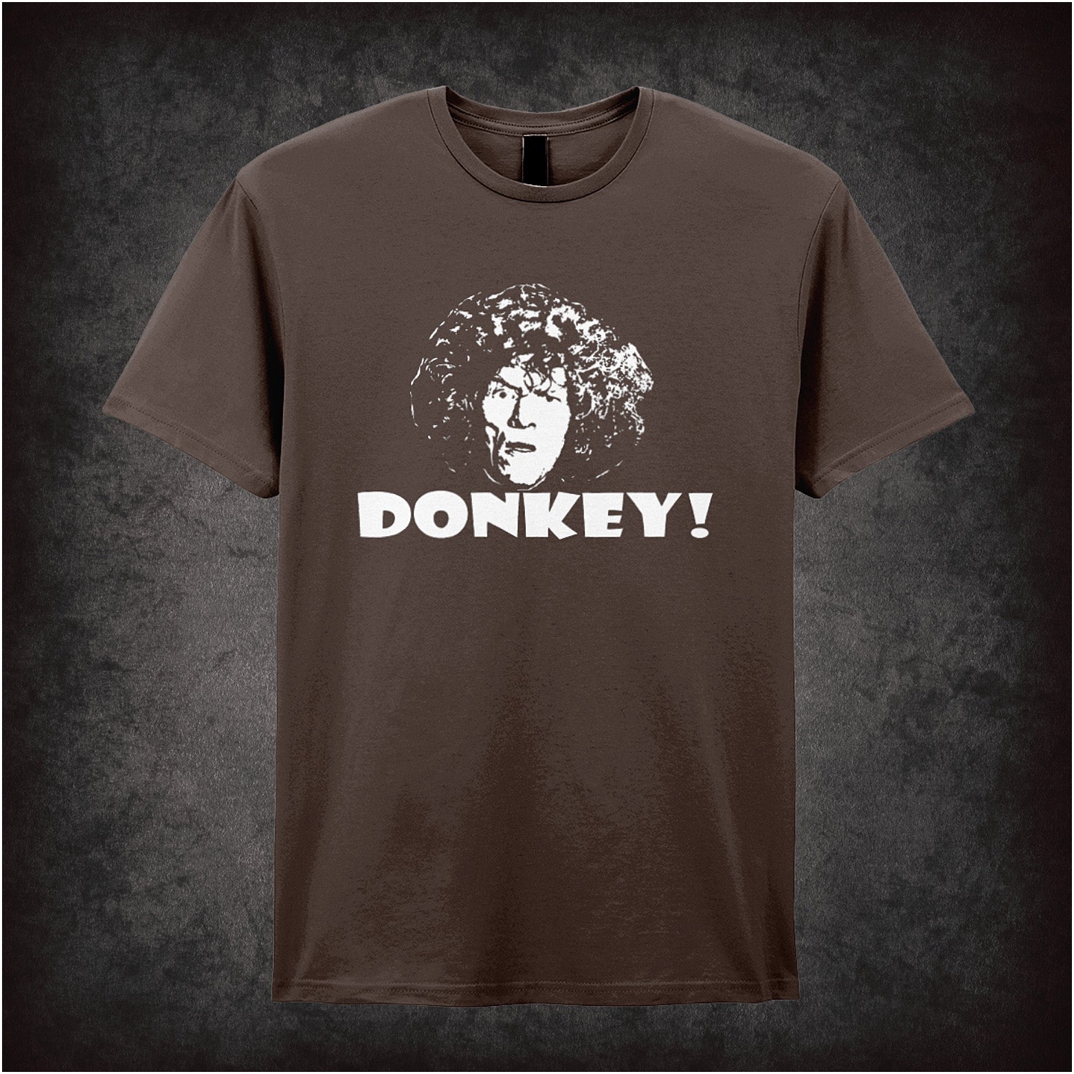 chocolate soft style unisex T-shirt featuring the word "Donkey" inspired by Shooting Stars, styled in bold, quirky lettering reflecting the show’s absurd humour.