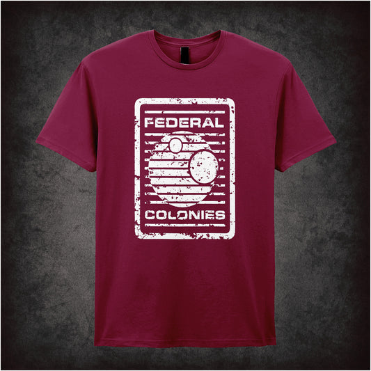 Federal Colonies – Total Recall-inspired design featuring a retro-futuristic space travel poster with bold text and planet imagery, printed on a cardinal red unisex t-shirt.