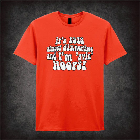 orange soft style unisex T-shirt featuring the quote "It's 1973, almost dinnertime and I'm 'avin' hoops" inspired by Life on Mars in bold retro lettering.