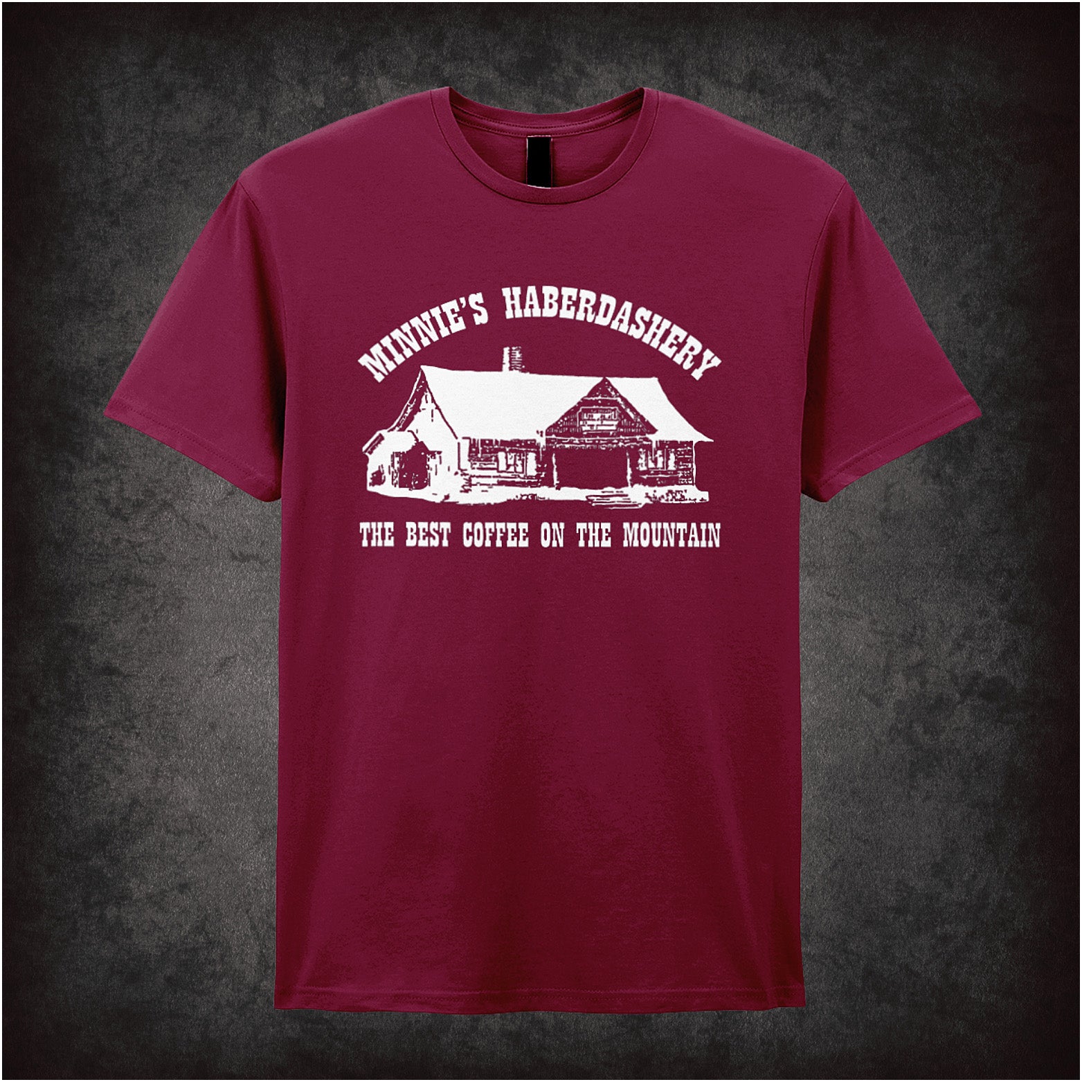 Cardinal red unisex t-shirt featuring a design with the text "Minnie's Haberdashery – The Best Coffee On The Mountain," inspired by The Hateful Eight, in vintage western-style lettering.