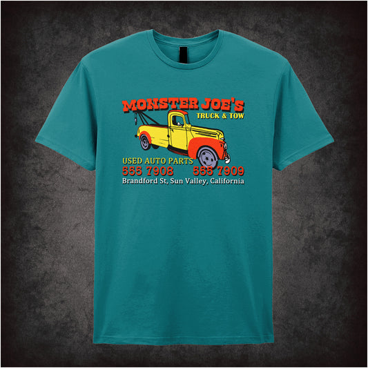 antique sapphire unisex T-shirt featuring “Monster Joe's Used Auto Parts” design inspired by Pulp Fiction, displayed in bold white lettering with a gritty, vintage style.