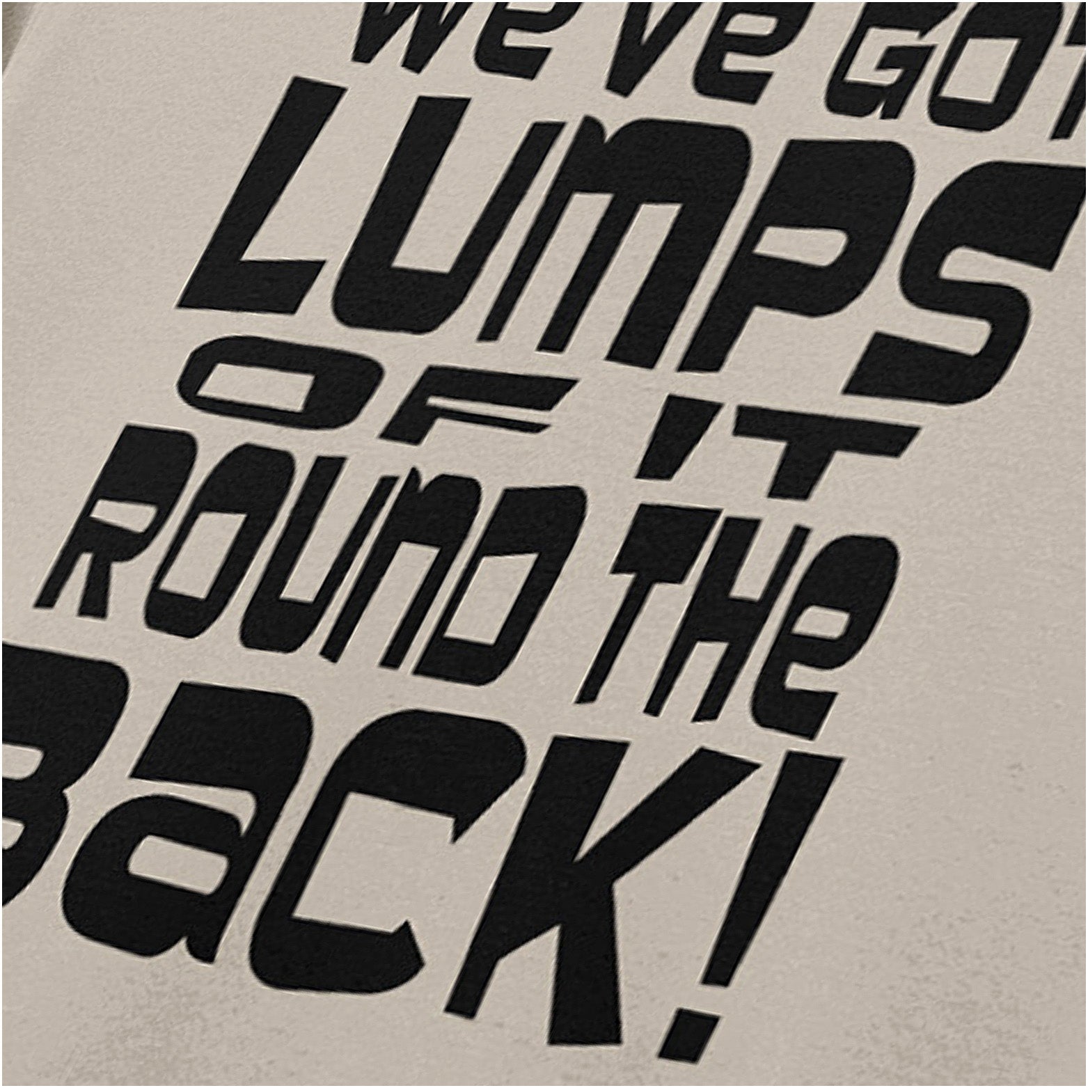 ‘We’ve got lumps of it round the back’ quote T-shirt close up in sand from Monty Python and the Holy Grail