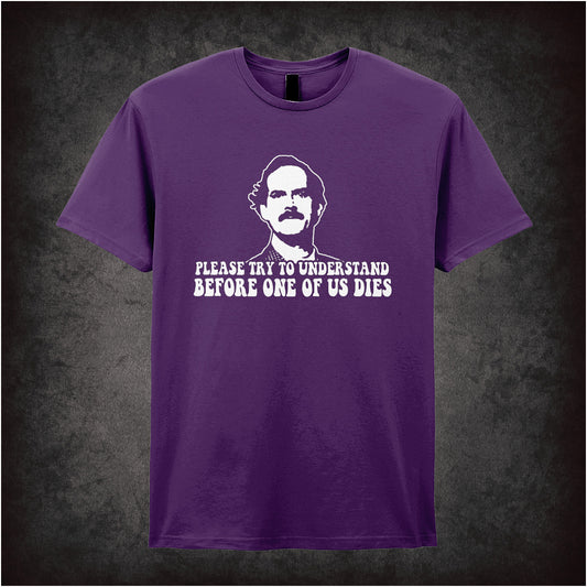 purple Soft style unisex T-shirt with the quote "Please Try to Understand Before One of Us Dies," inspired by Fawlty Towers, in a bold comedic design.